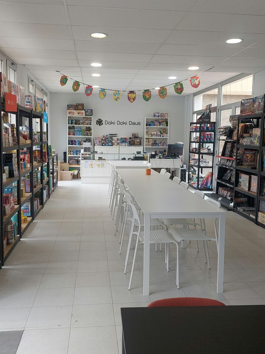 Interior de la tienda Doki Doki Daus en Mataró: estanterías de juegos y mesa para jugar